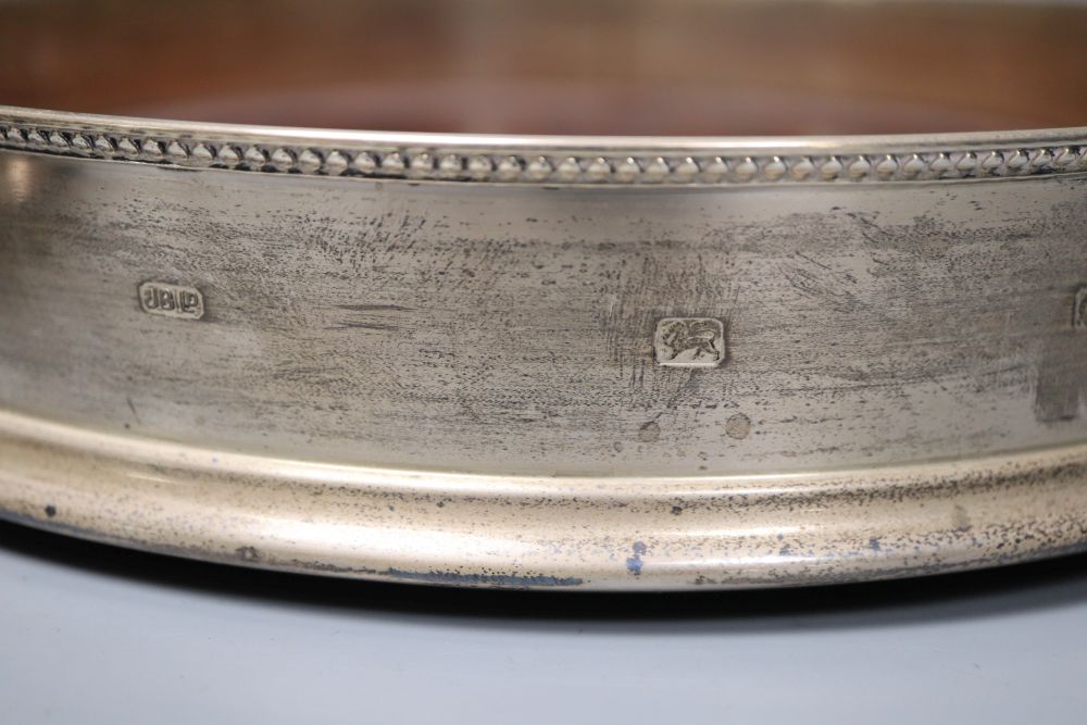 A large modern silver mounted table coaster, 25.7cm and two other modern wine coasters, one silver.